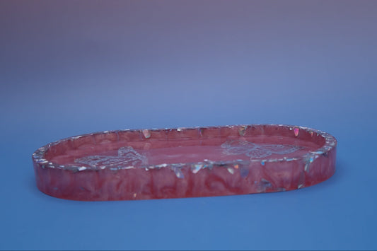 Bandeja decorativa em resina epóxi rosa, vista lateral, com acabamento translúcido e glitters holográficos nas bordas