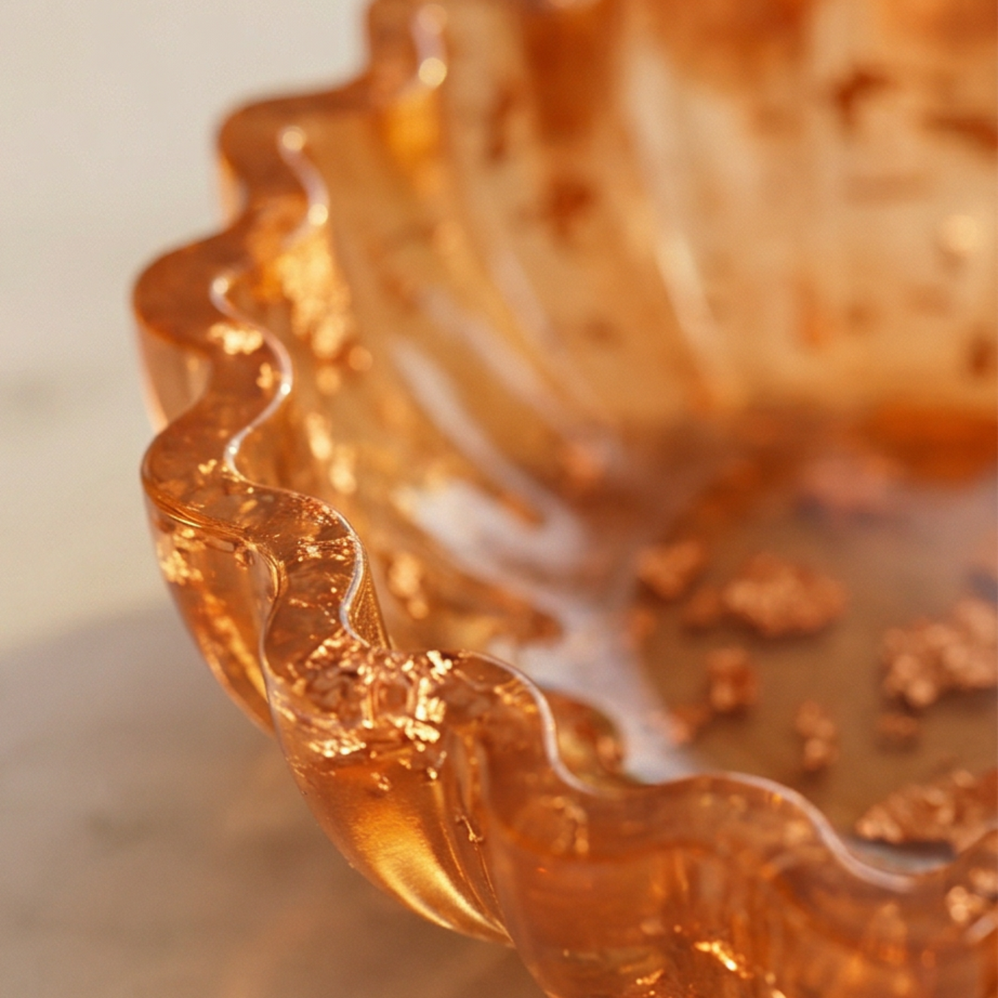 Detalhe de taça decorativa em resina caramelo com borda ondulada e flocos cobreado