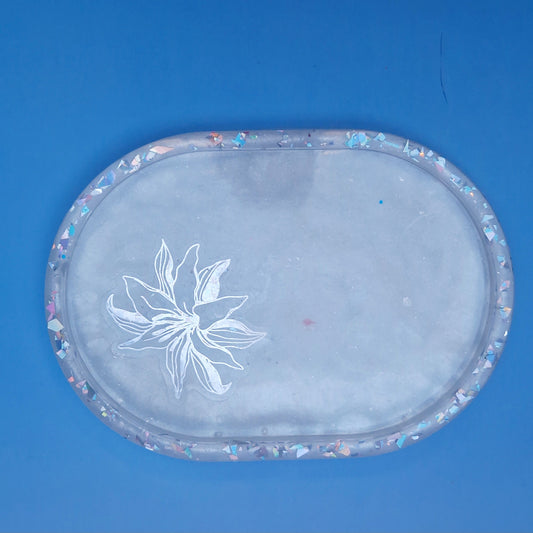 Vista superior de bandeja floral em resina epóxi branca com purpurinas holográficas no rebordo