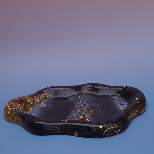 Prato decorativo orgânico em resina epóxi preta com detalhes em folha dourada, vista lateral, peça feita à mão