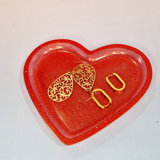 Taça decorativa em resina em forma de coração utilizada como porta-joias, acabamento vermelho brilhante com efeito artesanal.