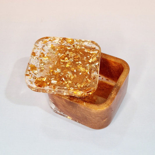 Caixa decorativa em resina com tampa, acabamento caramelo com efeito cobre e partículas metálicas, vista superior parcialmente aberta
