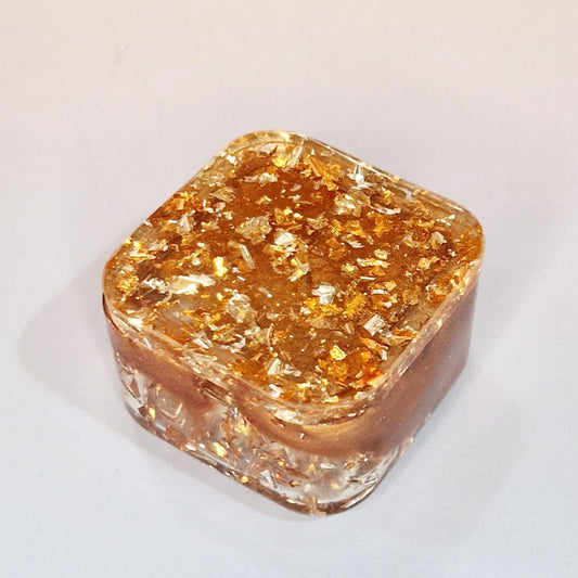 Caixa decorativa em resina com tampa, acabamento caramelo com efeito cobre e partículas metálicas, vista superior parcialmente aberta