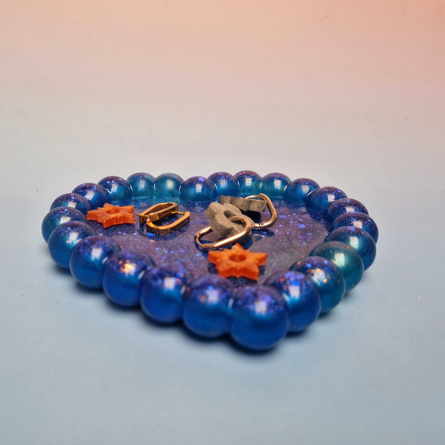 Prato decorativo em resina azul galáxia com formato de coração e relevo bubble, vista em perspetiva