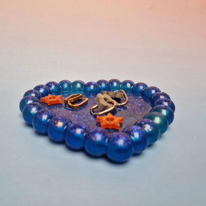 Prato decorativo em resina azul galáxia com formato de coração e relevo bubble, vista em perspetiva