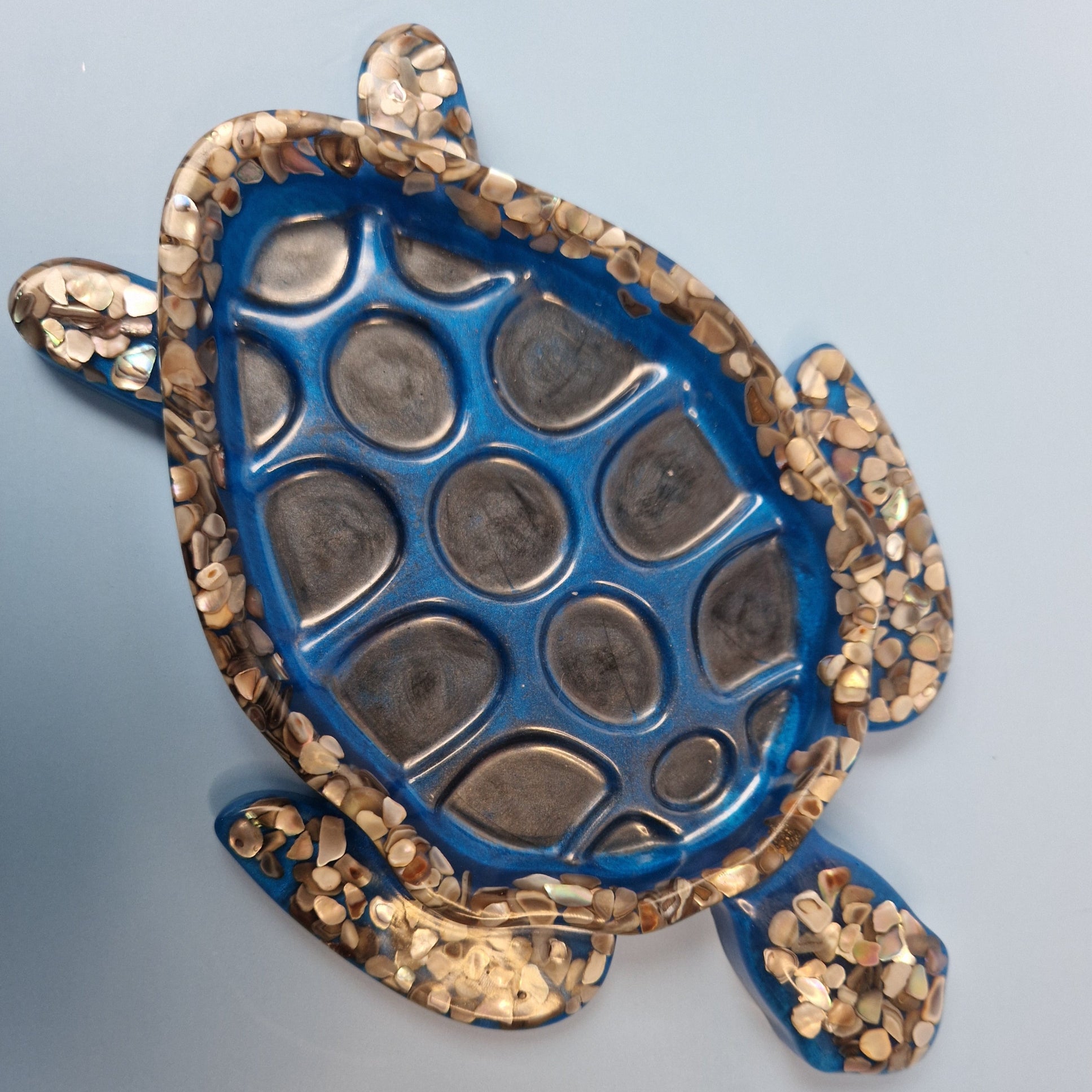 Tartaruga decorativa azul feita à mão em resina epóxi, detalhe da carapaça com relevo e acabamento brilhante.