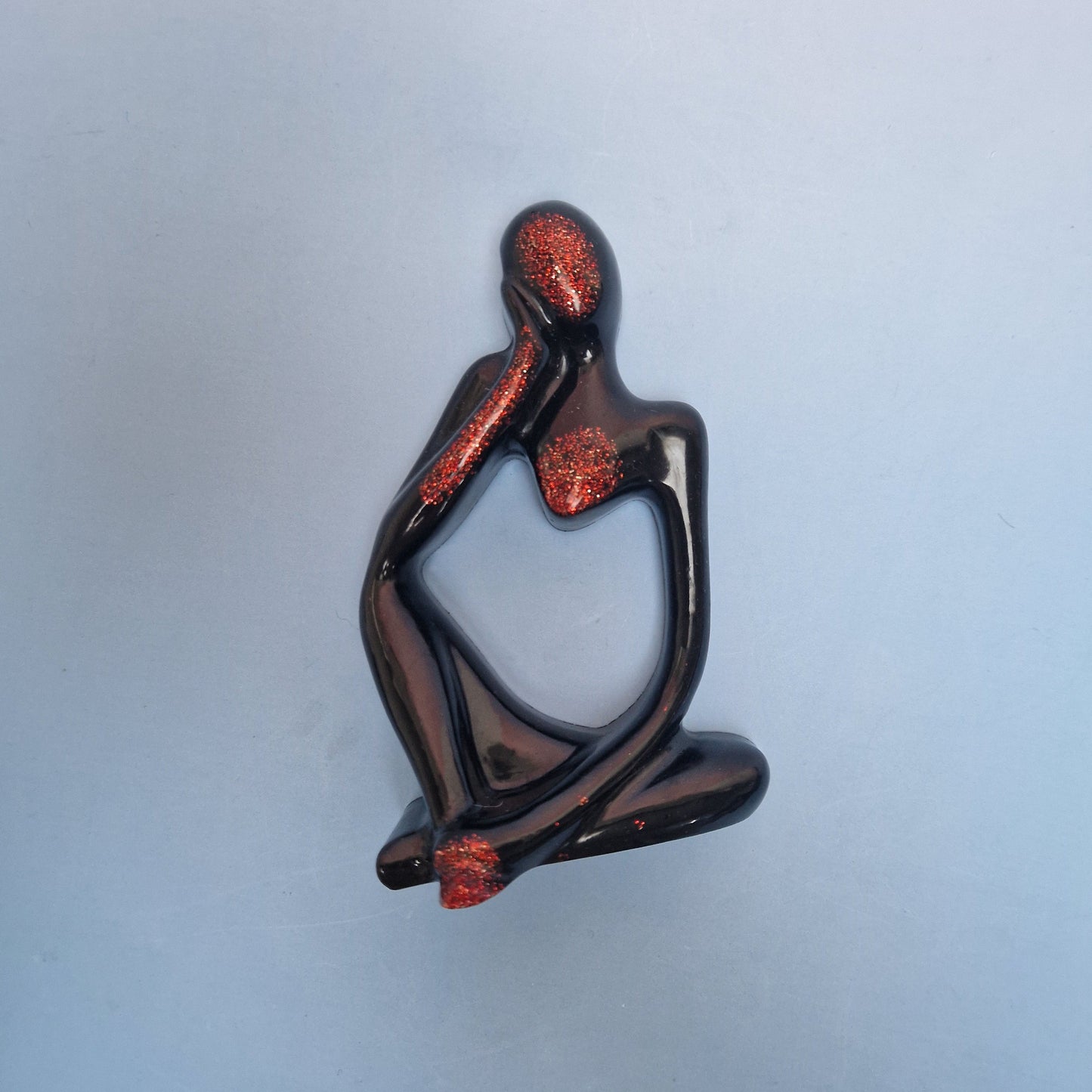 Figura abstrata decorativa em resina epoxy preta com detalhes em purpurina vermelha
