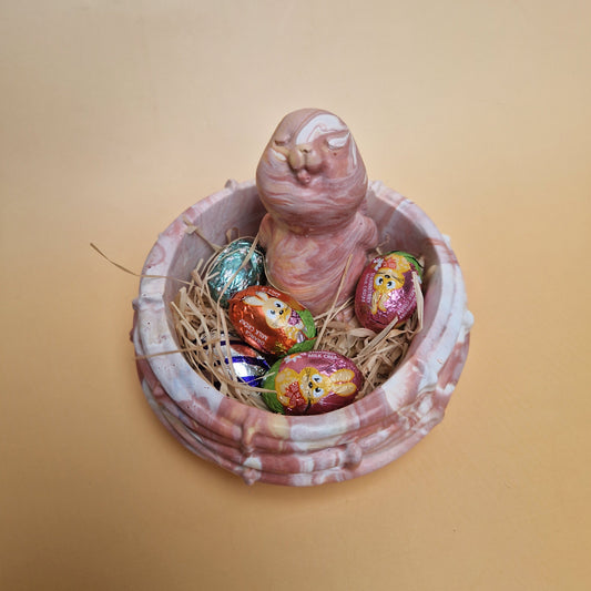 Decoração Páscoa com coelho rosa em Jesmonite dentro de ninho com ovos de chocolate