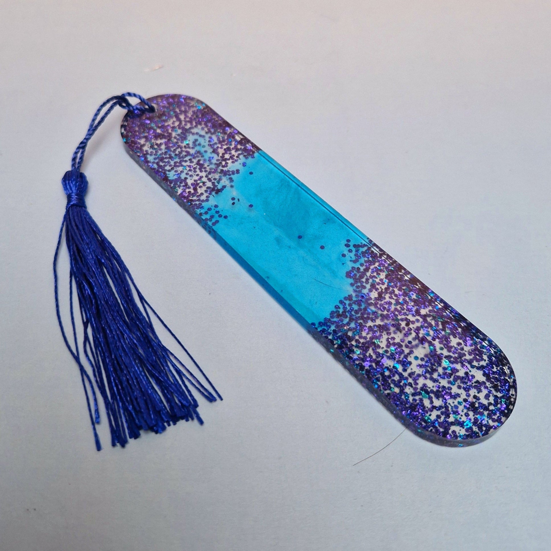 Marca-páginas artesanal em resina epóxi azul translúcido com purpurinas holográficas e tassel azul