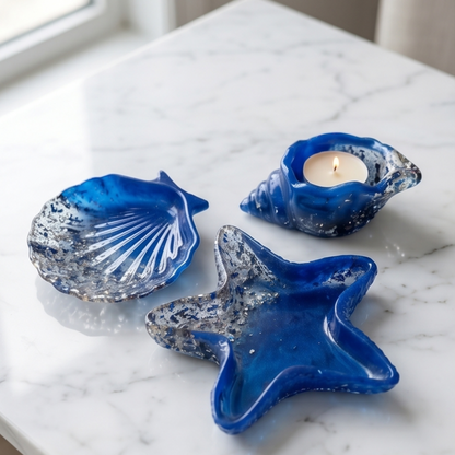 Conjunto decorativo em resina azul com estrela-do-mar, concha e búzio sobre superfície de mármore