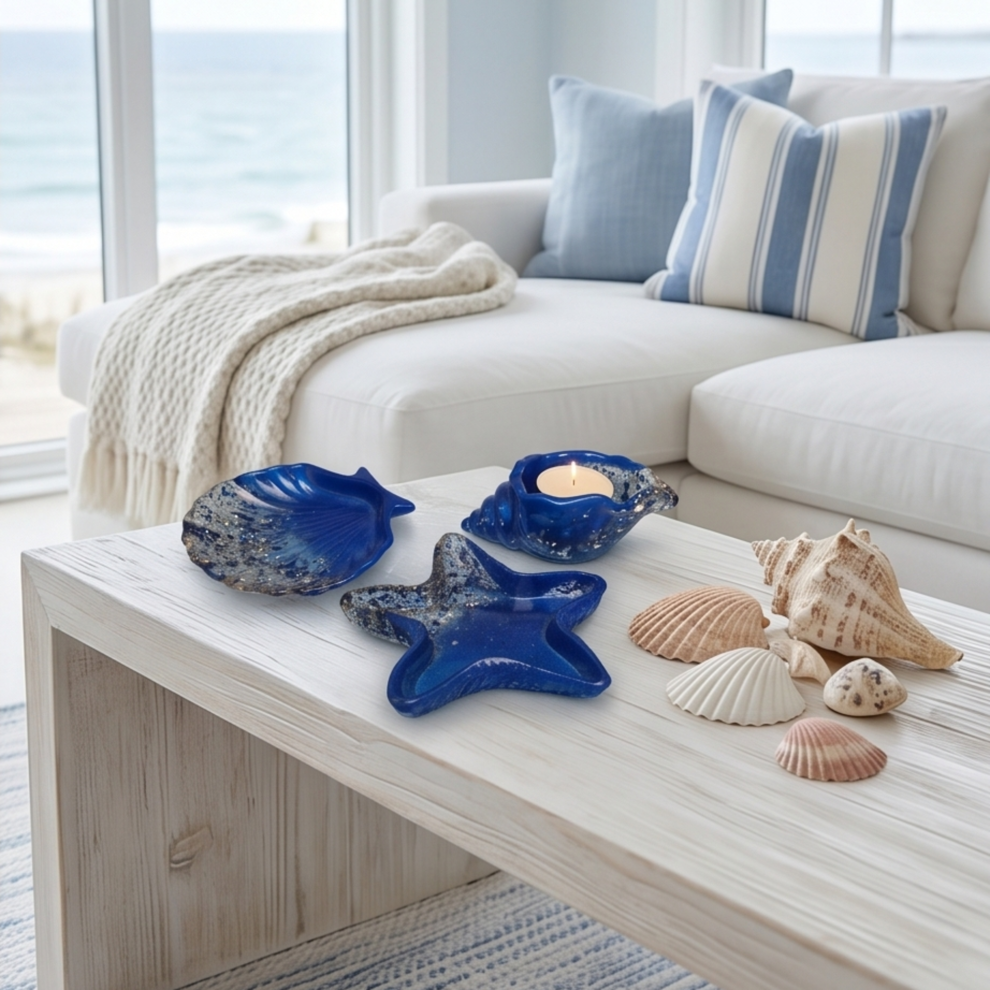 Conjunto decorativo em resina azul com formas marinhas sobre mesa com vista para o mar em ambiente luminoso
